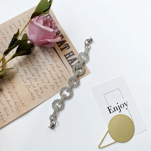 Detailed view of shimmering rhinestone inlaid silver circular chain on elegant aesthetic props