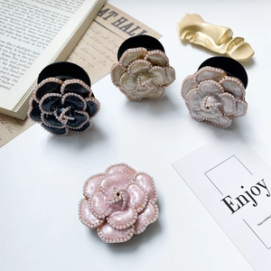 Detailed view of camellia phone grips with pearl edges on a white aesthetic background