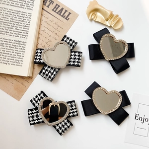 Detail of heart mirror phone grip with sparkling rhinestones and elegant ribbon bow tie