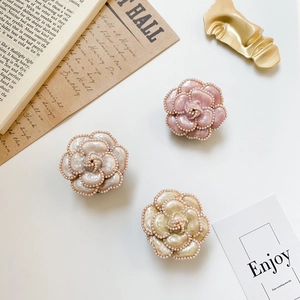 Detailed set of 3 camellia flower phone stands with pearls and glossy glazed finish