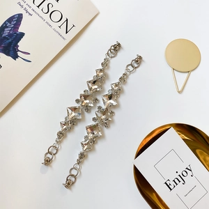 Detalle de dijes de strass plateados con cristales cuadrados y anillos de metal para zapatos