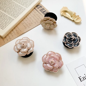Close-up of camellia phone grip with faux pearls and foldable air cushion stand