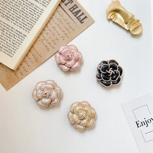 Detailed view of camellia flower phone stands with pearl accents in French vintage style