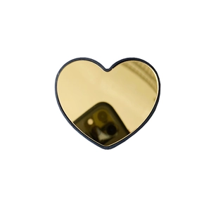 Detail shot of heart-shaped gold mirror phone stand with sleek black frame and glossy finish