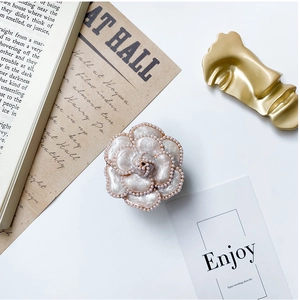 Detail of camellia pearl phone grip with elegant folding design and chic French style