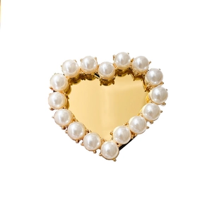 Macro shot of heart-shaped phone grip with pearl border and golden mirror center