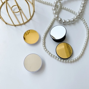 Macro shot of stylish folding heart-shaped phone grip mirrors on white minimalist background