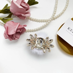 Detailed macro view of a luxury crystal rhinestones phone stand on white faux fur base