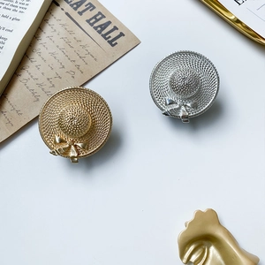 Macro view of gold and silver sun hat phone grips with detailed straw texture and bow