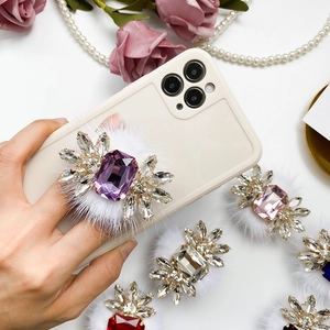 Close-up of luxury phone socket holder with rhinestones and pink faux fur trim