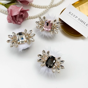 Macro detail of luxury crystal feather brooches with rhinestones and white fur trim