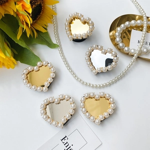 Detail of heart-shaped phone grips with pearl edge and mirror finish in gold and silver