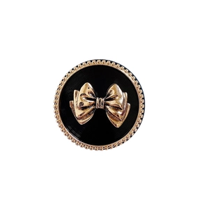 Macro detail of vintage metal bowknot phone grip with gold trim and textured black base
