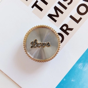 Detail of a vintage bow-style phone socket featuring a golden Love logo and beaded edge