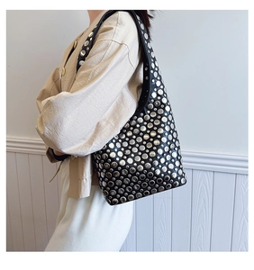 Détail d'un sac sous les aisselles en cuir noir avec des clous argentés de style punk