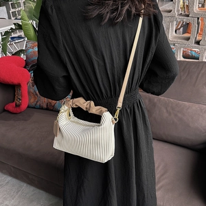 Chic pleated cloud bag in creamy white with brown ruffled handle and crossbody strap