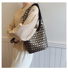 Détails des rivets argentés et du cuir marron mat d'un sac à bandoulière vintage