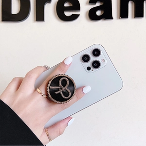 Vintage black phone grip featuring a gold bow-knot design on a white smartphone