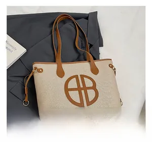 Detailed view of the AB logo and brown leather stitching on the canvas tote bag