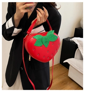 Détail du sac à main fraise rouge avec feuilles pailletées et rivets en métal