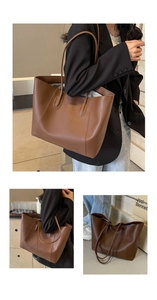 Detail view of large brown matte leather tote bag showing double straps and texture
