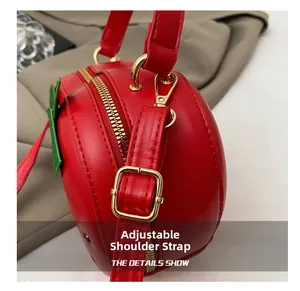 Vue détaillée du sac fraise rouge montrant la bandoulière réglable et boucle dorée