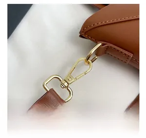 Détails de la bandoulière en cuir marron avec fermoir mousqueton doré et coutures fines