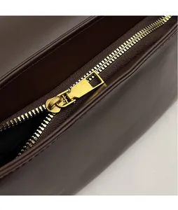 Detail of vintage brown leather bag with smooth gold zipper and neat stitching