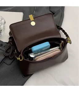 Deep brown leather shoulder bag interior showing spacious capacity and gold clasp