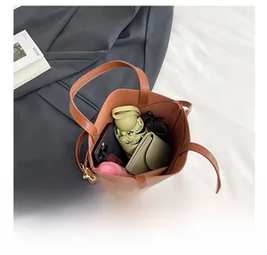 Sac seau en cuir marron montrant sa capacité pour téléphone, parapluie et accessoires