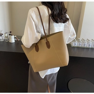 Detailed side view of the large leather tote bag worn over the shoulder for commute