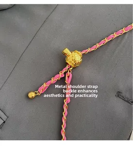 Detail of pink leather woven chain with a golden quilted ball strap adjuster buckle