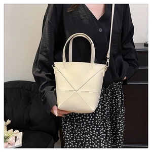 Détail du sac seau blanc cassé avec surpiqûres géométriques et bandoulière réglable