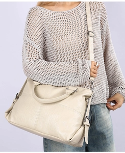 Detailed view of large cream crossbody bag with leather texture and adjustable strap