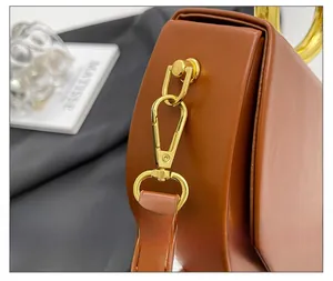 Detail of high-quality gold hardware and caramel leather on the shoulder bag side