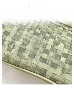 Detailed macro view of light green Intrecciato woven texture on a small pillow bag