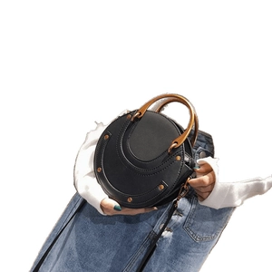 Circular black leather shoulder bag with wooden handle and vintage metal rivets details