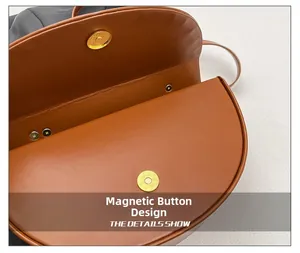 Detail shot of the brown leather box bag showing the magnetic buckle closure design