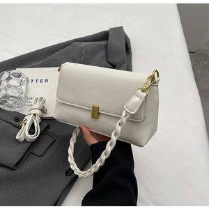 Detailed view of white faux leather bag with gold buckle and dual detachable straps