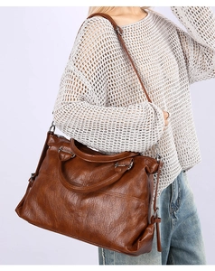 Detail of vintage brown large capacity shoulder bag with tassels and shoulder strap