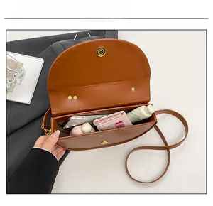 Brown semi-circle crossbody bag showing interior capacity for essentials and phone