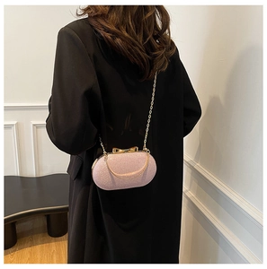 Detail of pink sequin evening bag with gold chain strap and bow clasp decoration