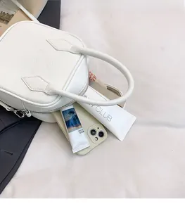 Internal view of a white pebble leather handbag showing spacious storage for essentials