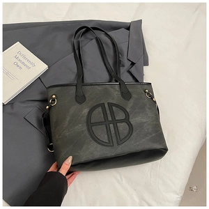 Detail of grey matte tote bag with black B logo on a blazer background