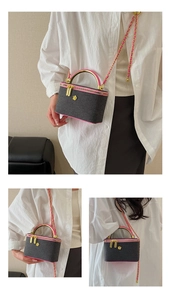 Detail of grey tweed vanity case with pink trim, gold chain strap and floral metal clasp
