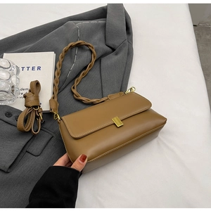 Detail of vintage camel faux leather underarm bag with gold buckle and dual straps