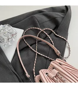 Detailed view of pink accordion pleat bucket bag with silver metal chain leather strap