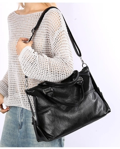 Detailed side view of black vintage textured large capacity tote bag with silver hardware