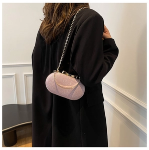 Detail of pink glitter hard shell evening bag with gold bow clasp and chain strap