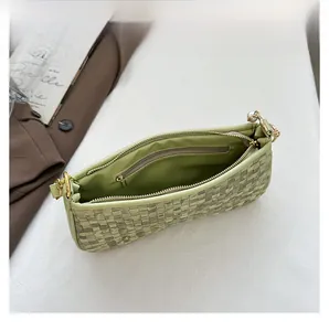 Detail view of woven handbag interior featuring smooth lining and pearl zipper pocket